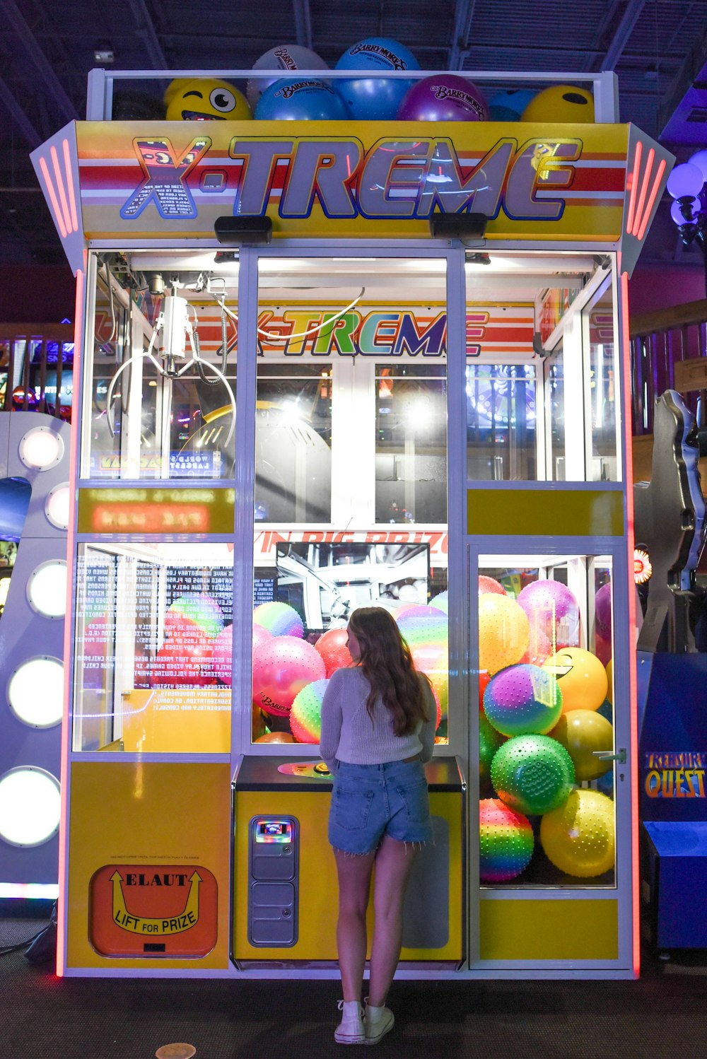 woman standing in front of X-treme arcade machine