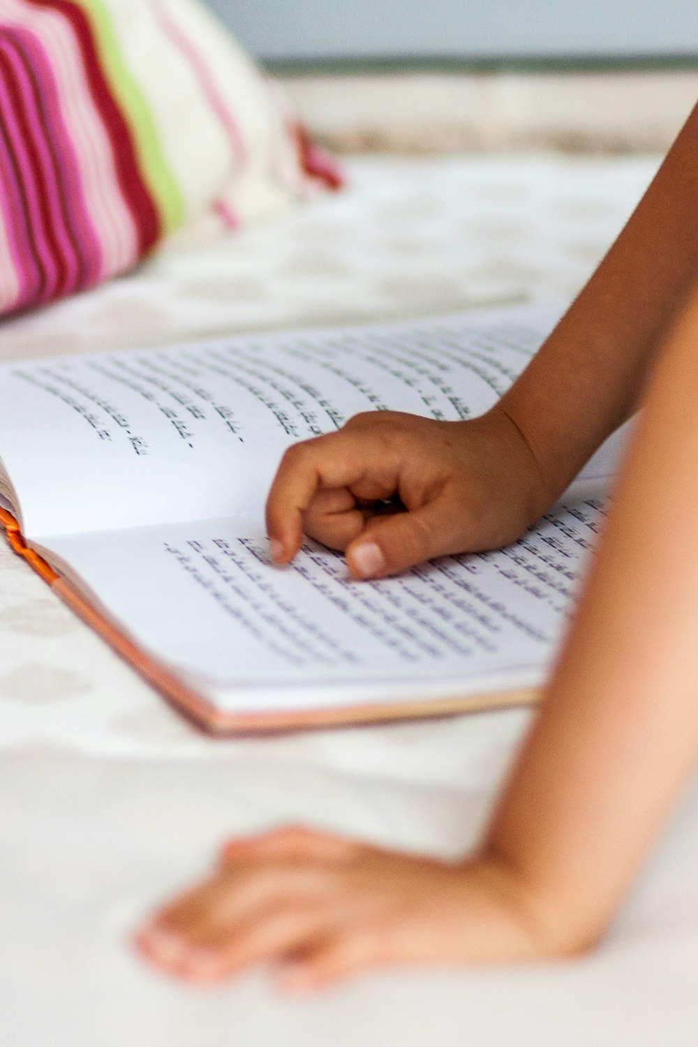 mano del bambino che indica il libro di sceneggiatura Devanagari