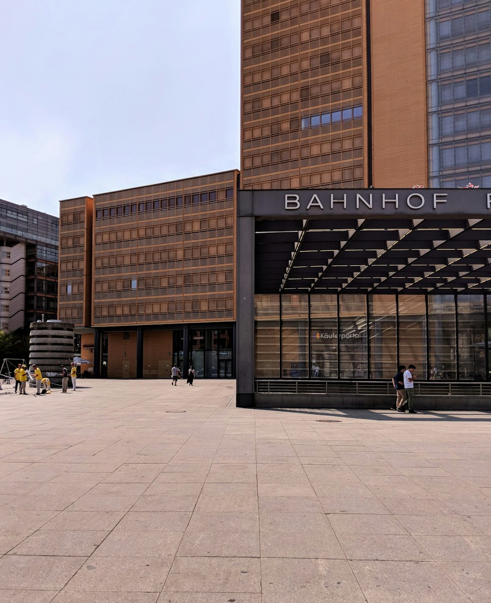 people walking near Bahnhof building