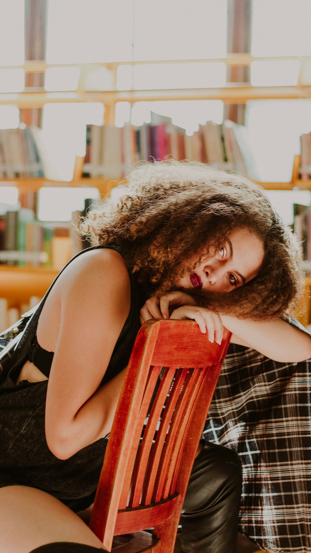 selective focus photography of woman sitting on chair while resting head on backrest