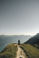 person hiking above mountain overlooking river