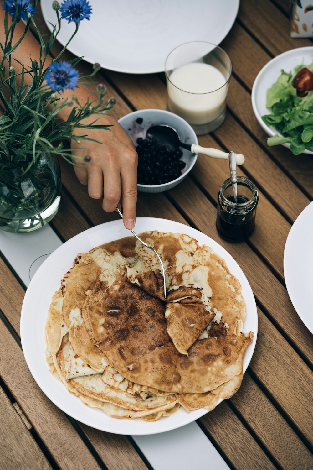 person holding fork on pancake