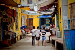 three boys walking between buildings at daytime