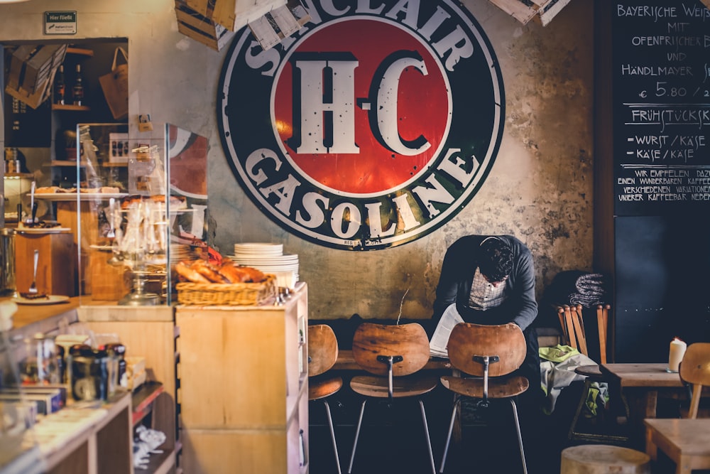 man sitting on chair beside signage