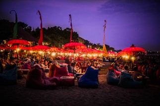 A lively sunset beach scene in Goa with colorful umbrellas and people enjoying the evening.