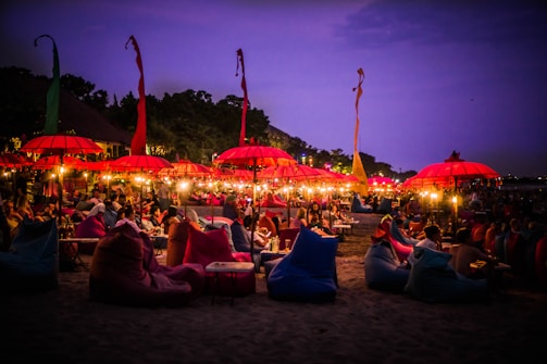 A lively sunset beach scene in Goa with colorful umbrellas and people enjoying the evening.