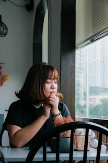 woman sitting near clear glass window