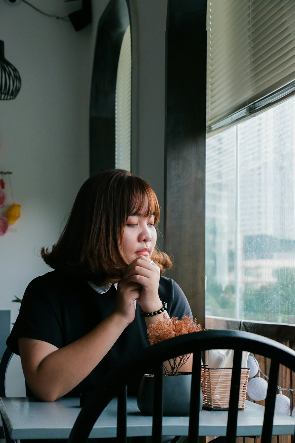 woman sitting near clear glass window