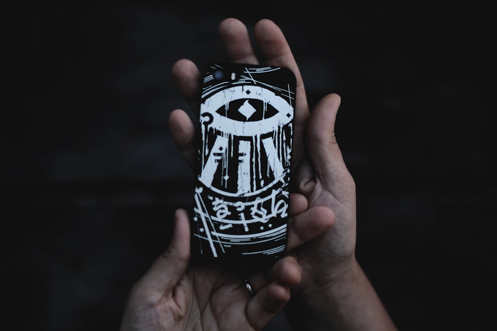 person holding black and white phone case