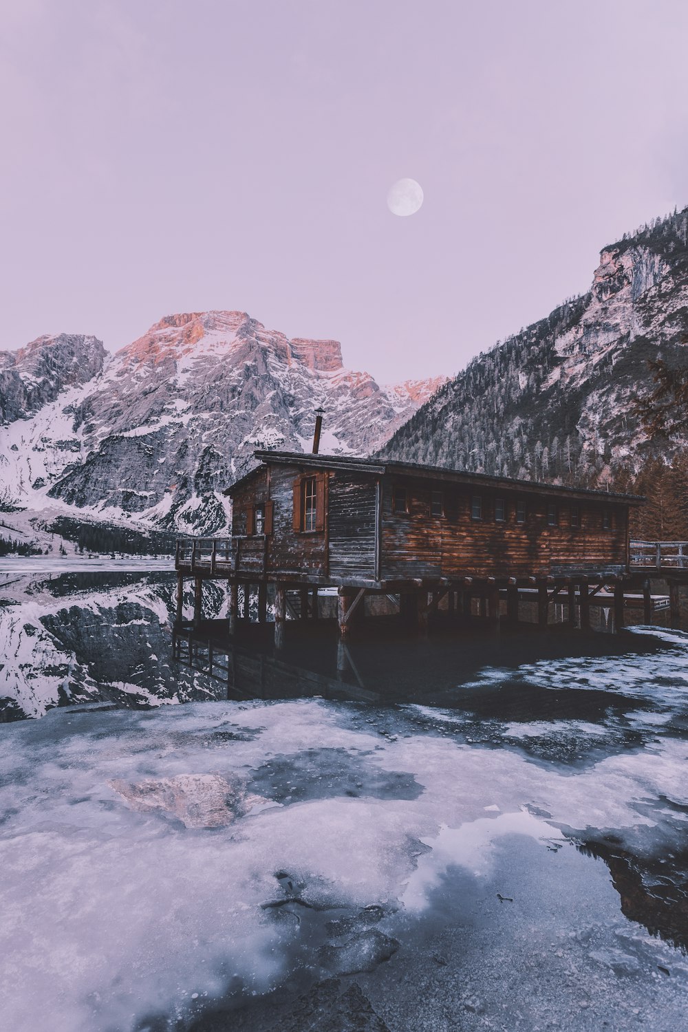 Casa de madera marrón junto a la montaña