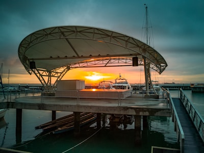 A wide shot of a marina with various boats bathed in the soft glow of early evening light.