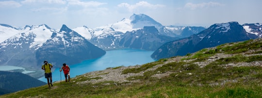 two people climbing on top of mountain in Garibaldi Lake Canada