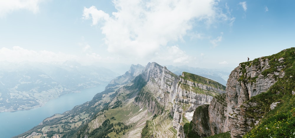 person standing on top of mountain overlooking body of water