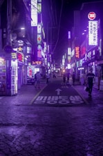 A bustling Seoul street at night, glowing with neon signs and the energy of K-pop fans.