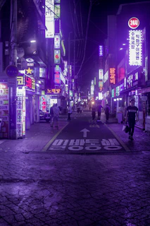 A bustling street in Seoul lit up with colorful neon signs at night