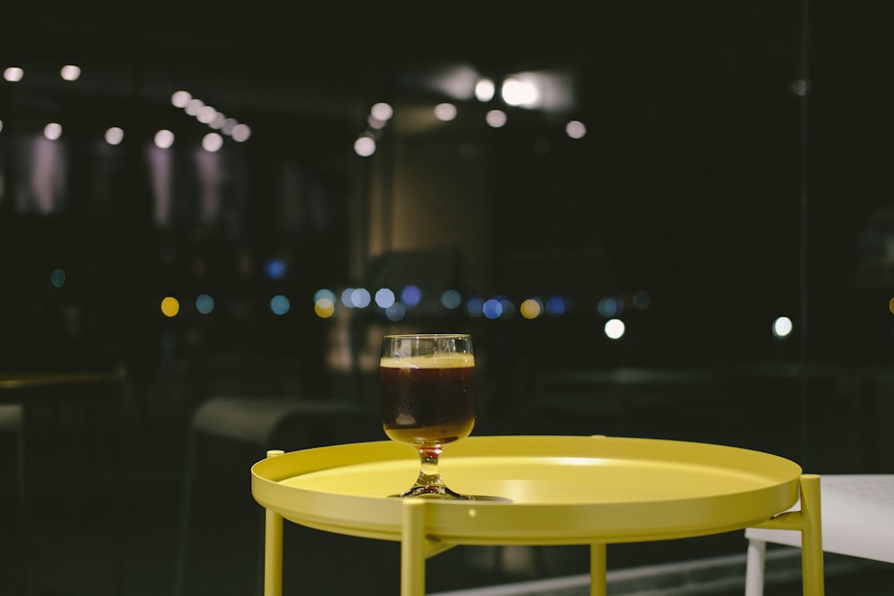 Selektives Fokusfoto eines Weinglases, das auf einem grünen Tisch platziert ist