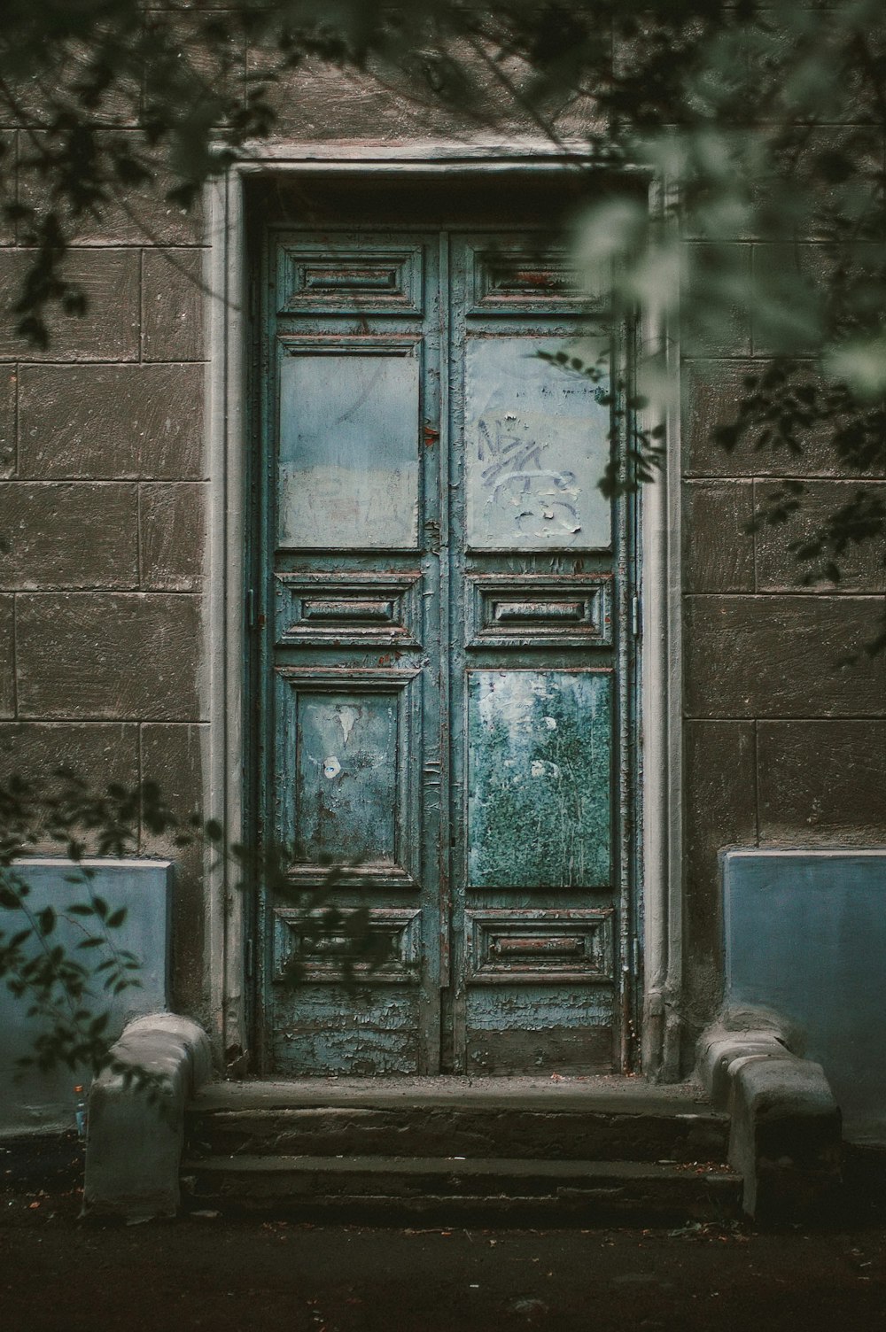 Porte en bois turquoise sur mur en béton gris