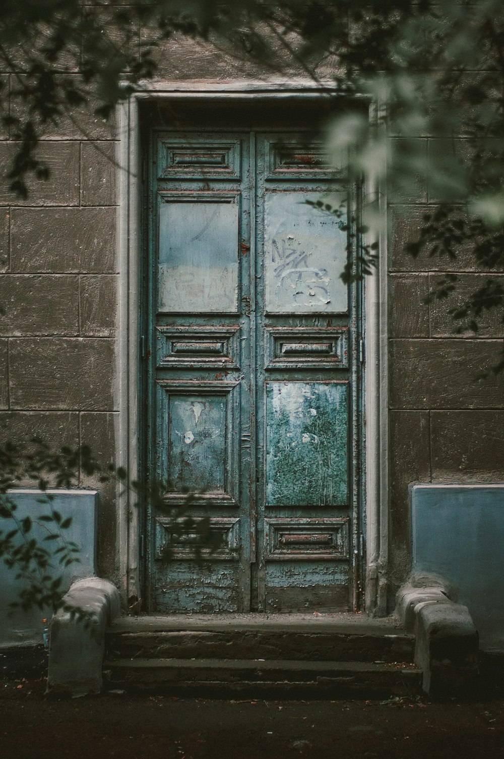 teal wooden door on gray concrete wall