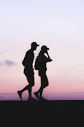 silhouette photo of man and woman wearing caps