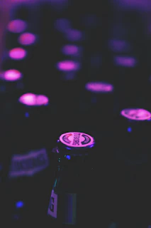 Stack of sample pack covers illuminated by soft purple lighting on a black surface.