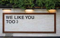 We Like You signage on white tile