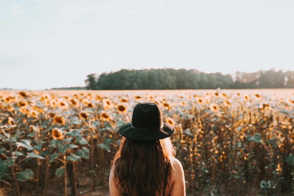 Mujer de pie en el jardín de girasoles