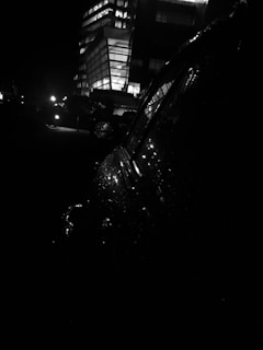 Nighttime view of a high-rise building with illuminated elevator media screens visible through glass