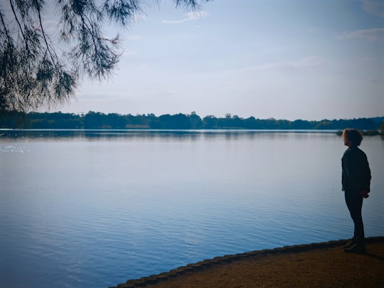 woman standing alone facing body of water in Canberra Australia