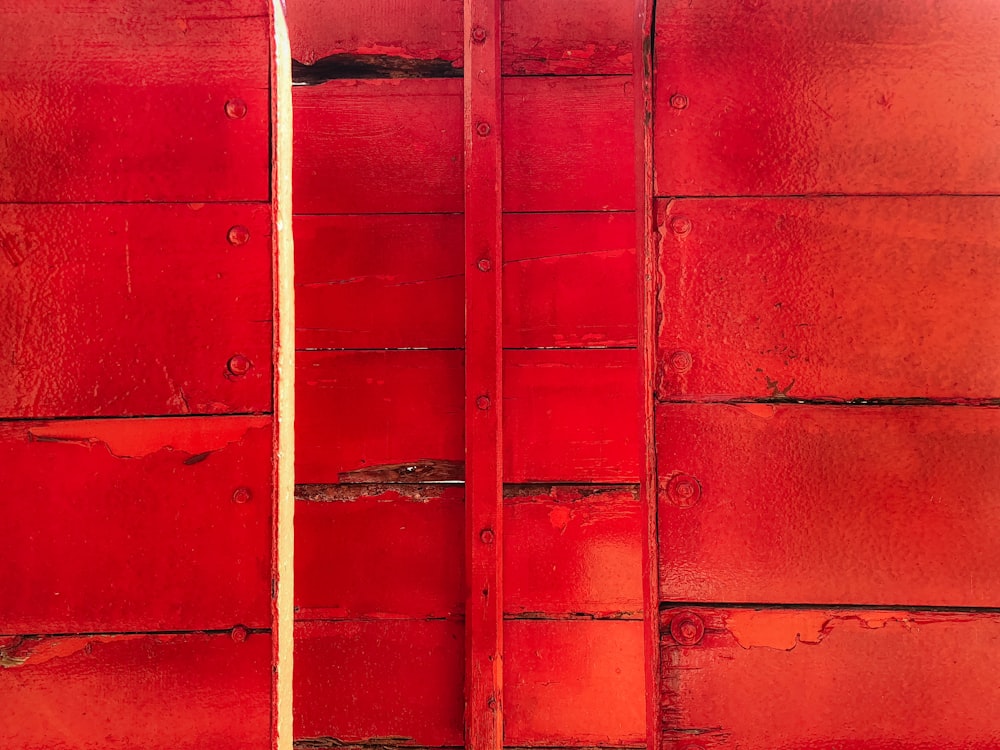 un primo piano di un muro rosso con una tavola da surf che sporge da esso