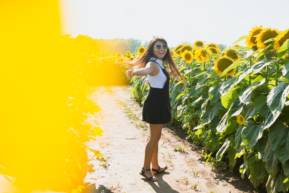 Frau steht im Sonnenblumenfeld