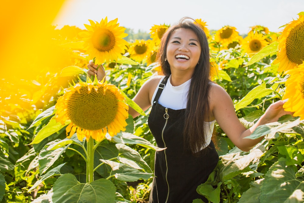 Mujer rodeada de girasoles durante el día