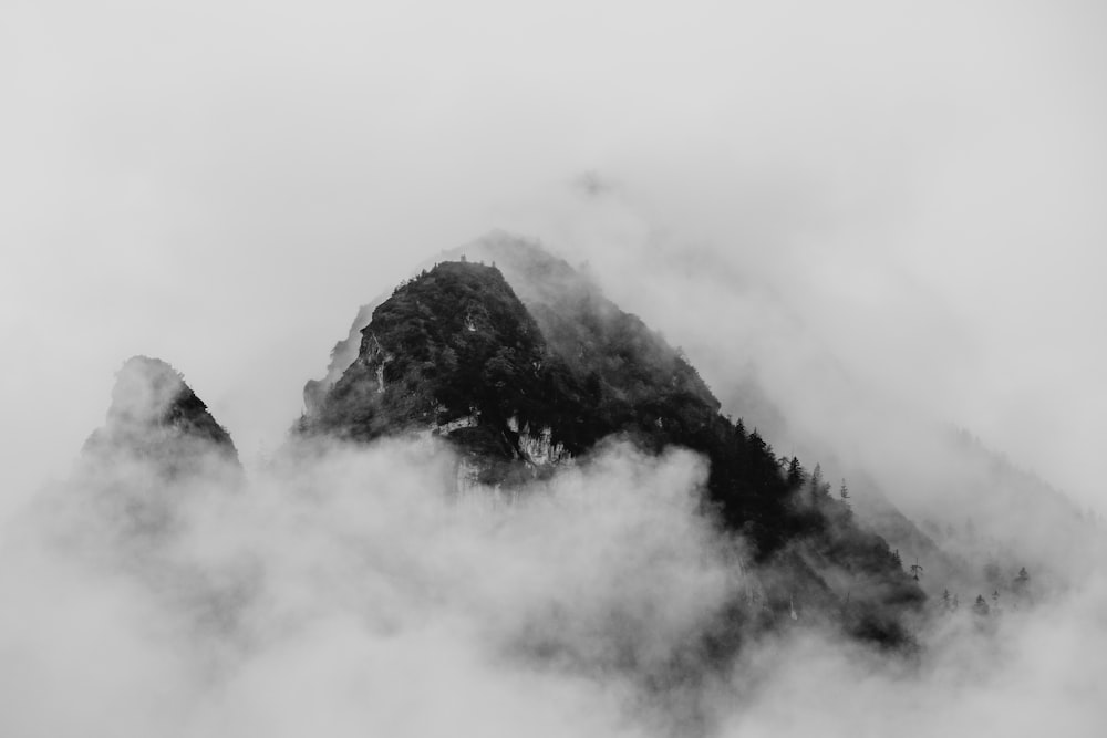 foto em tons de cinza da montanha coberta por nuvens