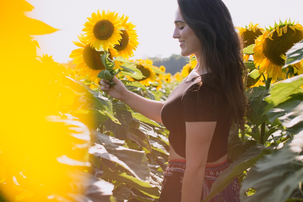 selective focus of woman standing between sunflowers