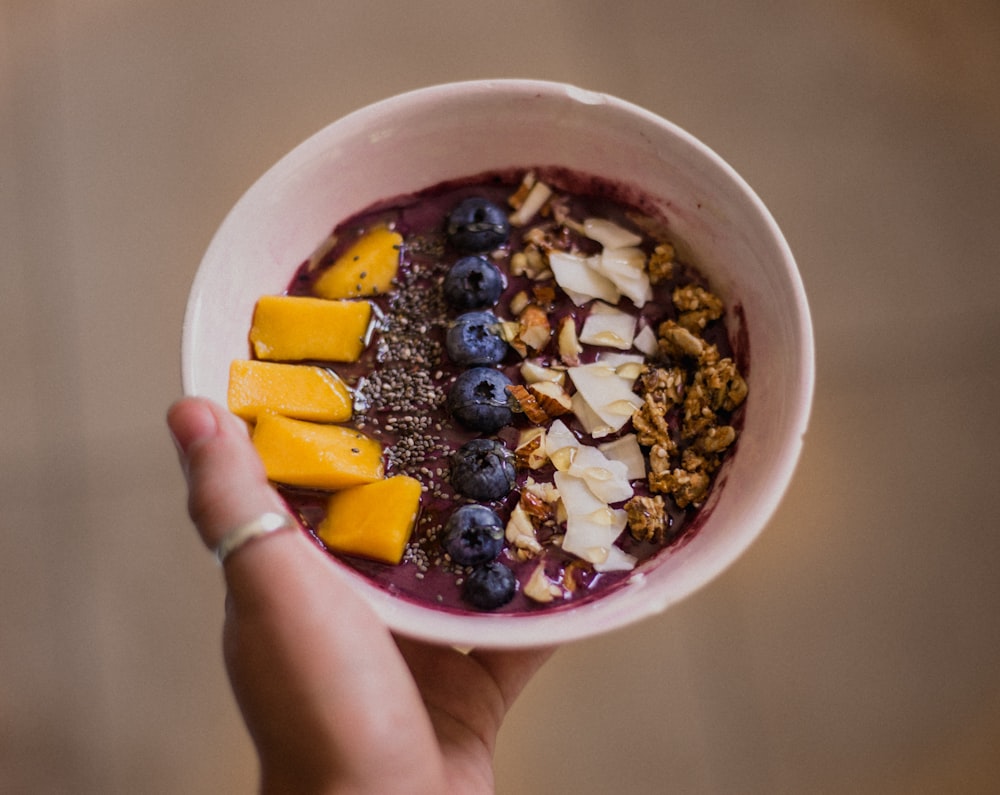 person holding bowl with food