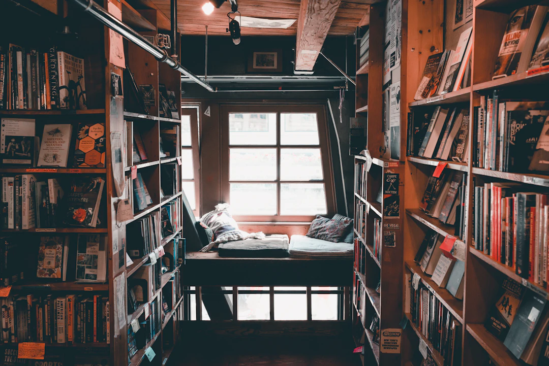 A cozy attic bookshop with a cushioned reading nook by the window