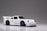 A small, detailed model car with a sleek white finish and prominent black detailing. The car features a spoiler, black wheels, and intricate headlight designs.