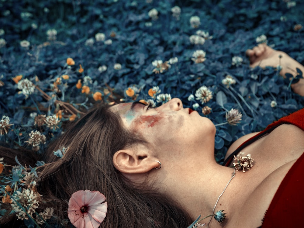 a woman laying in a field of flowers