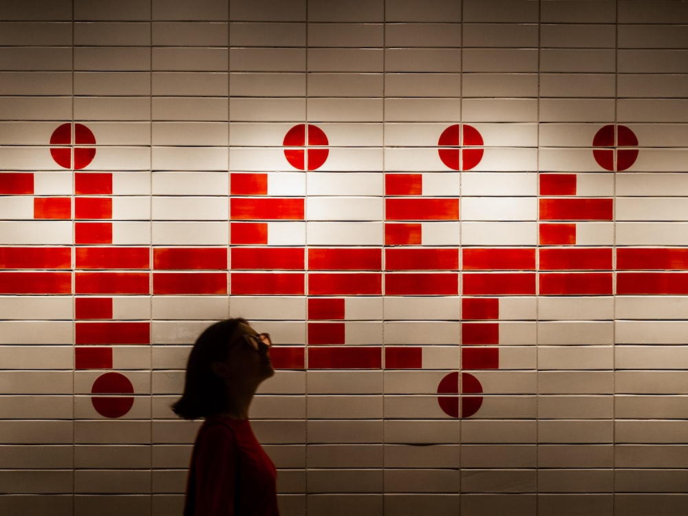 woman standing beside red and white wall