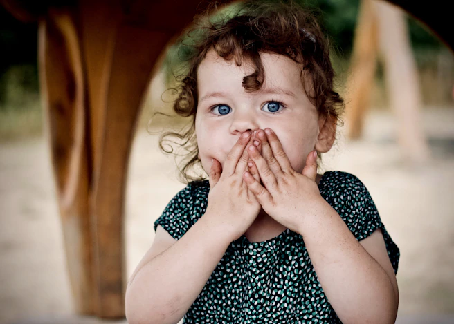 toddler holding her lips