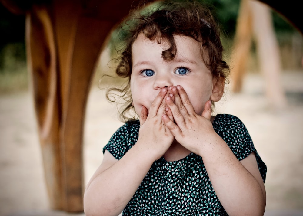 toddler holding her lips