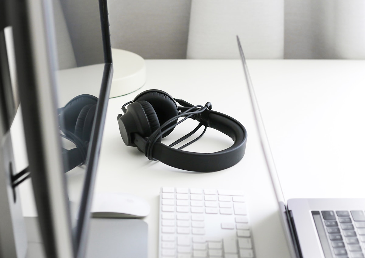 Black corded headphones on white wooden table