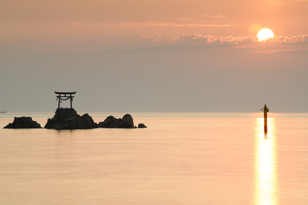 silhouette of arch on rocks during sunset