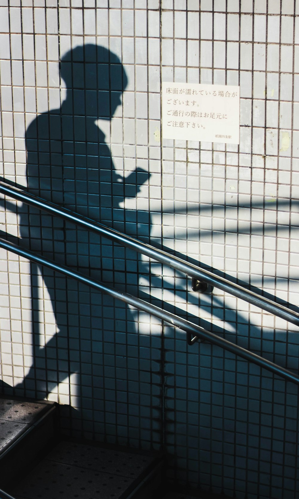 human shadow beside gray wall