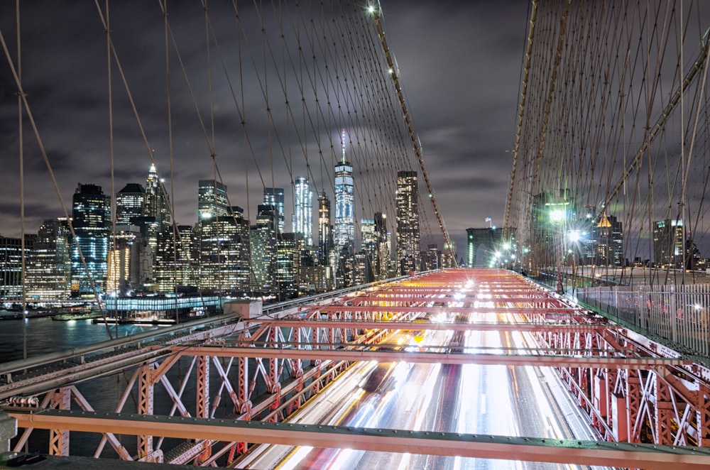 Puente de metal rojo con vistas a un edificio de gran altura