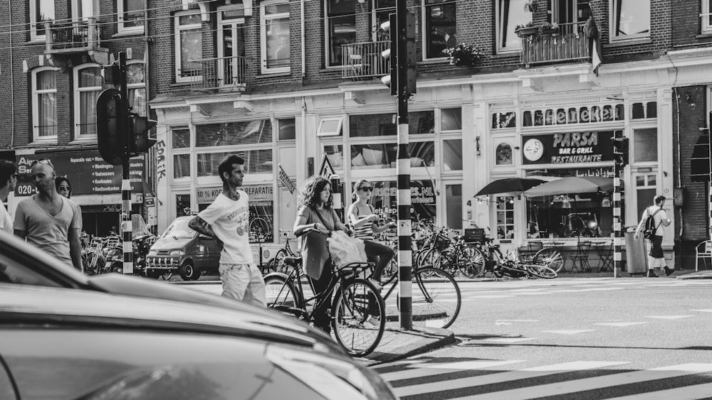 grayscale photography of people walking across street