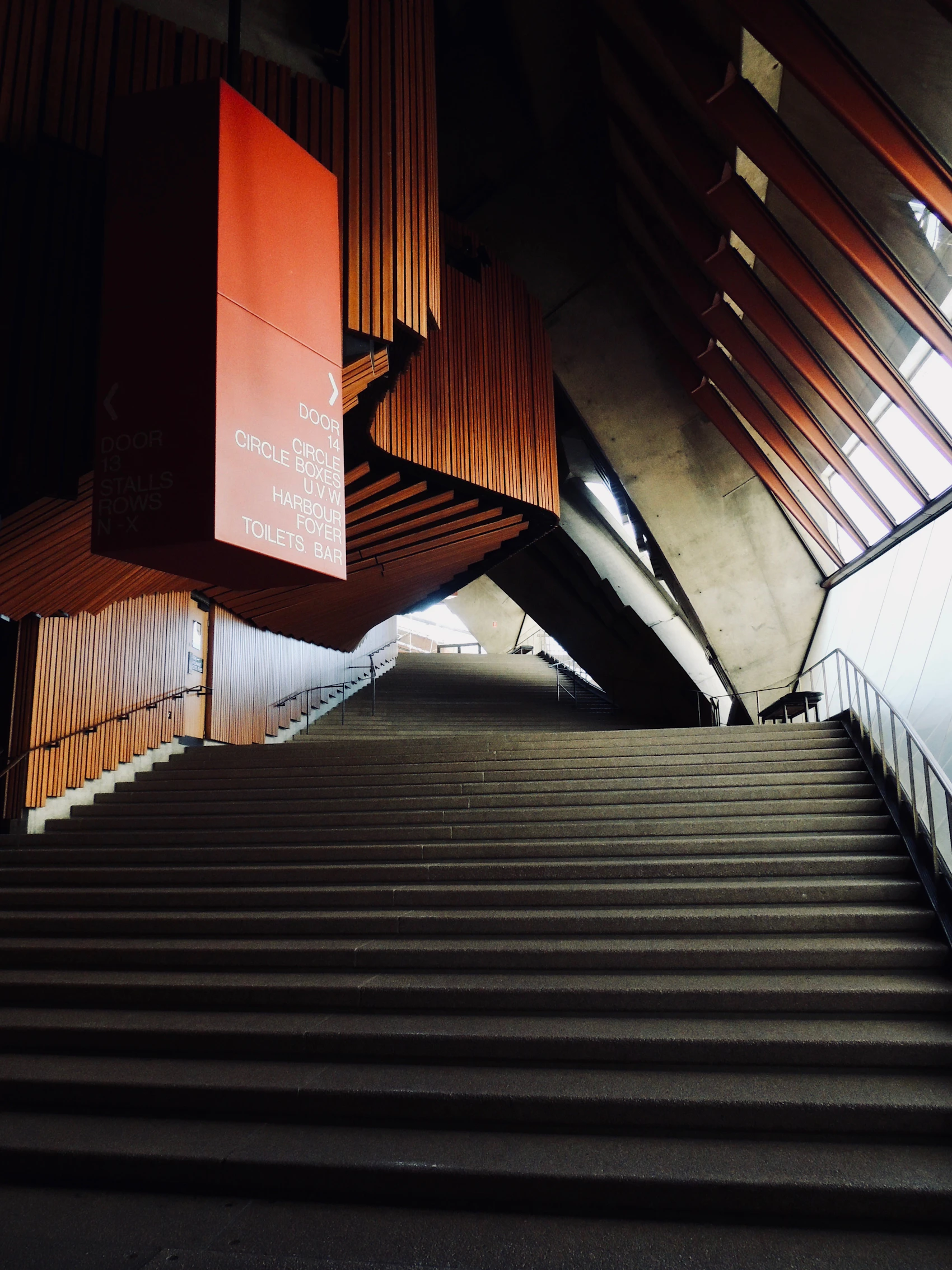 Concrete and timber staircase inside the Sydney Opera House lit by warm light