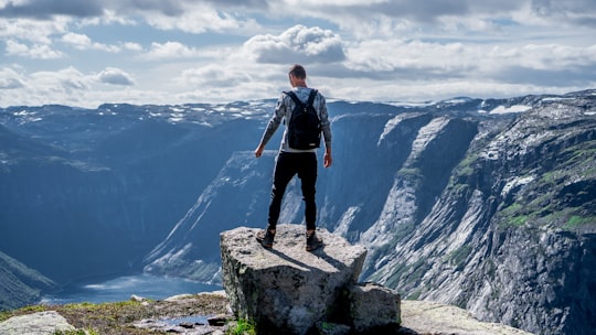 man standing on edge of cliff in Trolltunga Norway