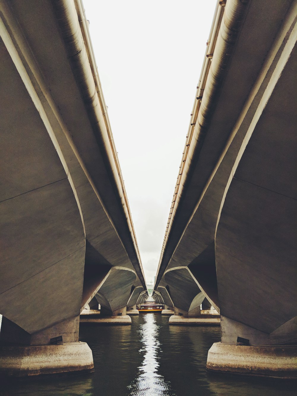 zwei graue Betonbrücken auf Gewässer