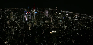 A sleek nighttime aerial view of a bustling North American city skyline illuminated with deep navy and gold tones, symbolizing opportunity and sophistication.