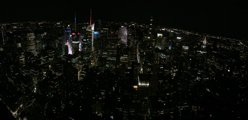 A sleek nighttime aerial view of a bustling North American city skyline illuminated with deep navy and gold tones, symbolizing opportunity and sophistication.